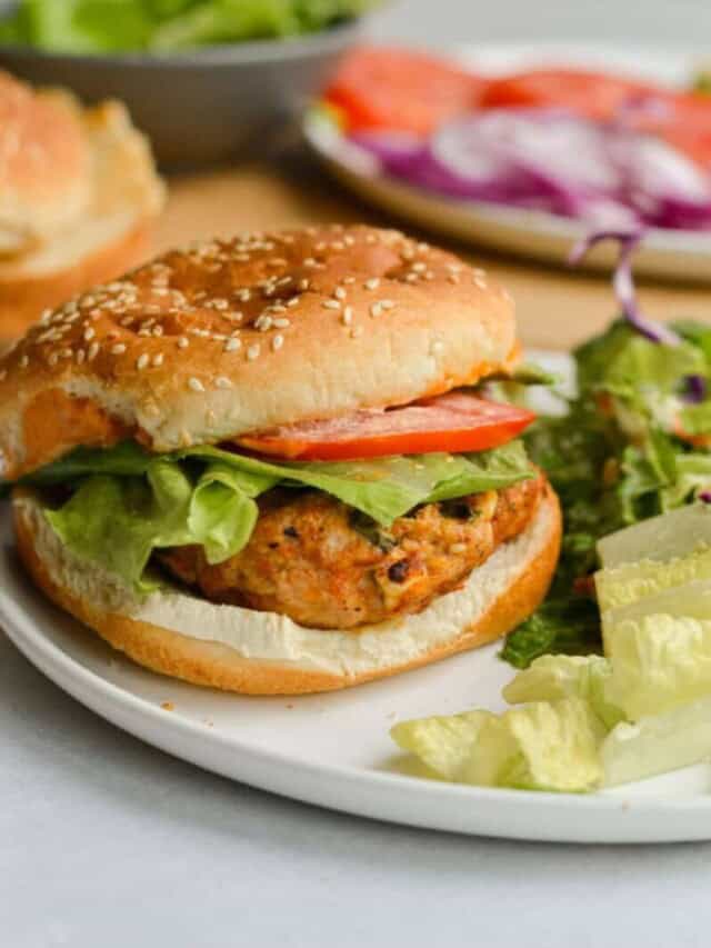 Spicy feta chicken burgers on a plate with salad.