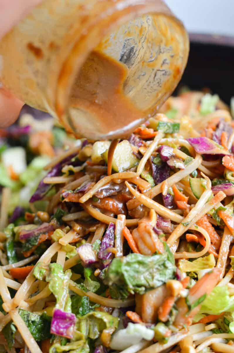 Pouring dressing over spring roll salad.