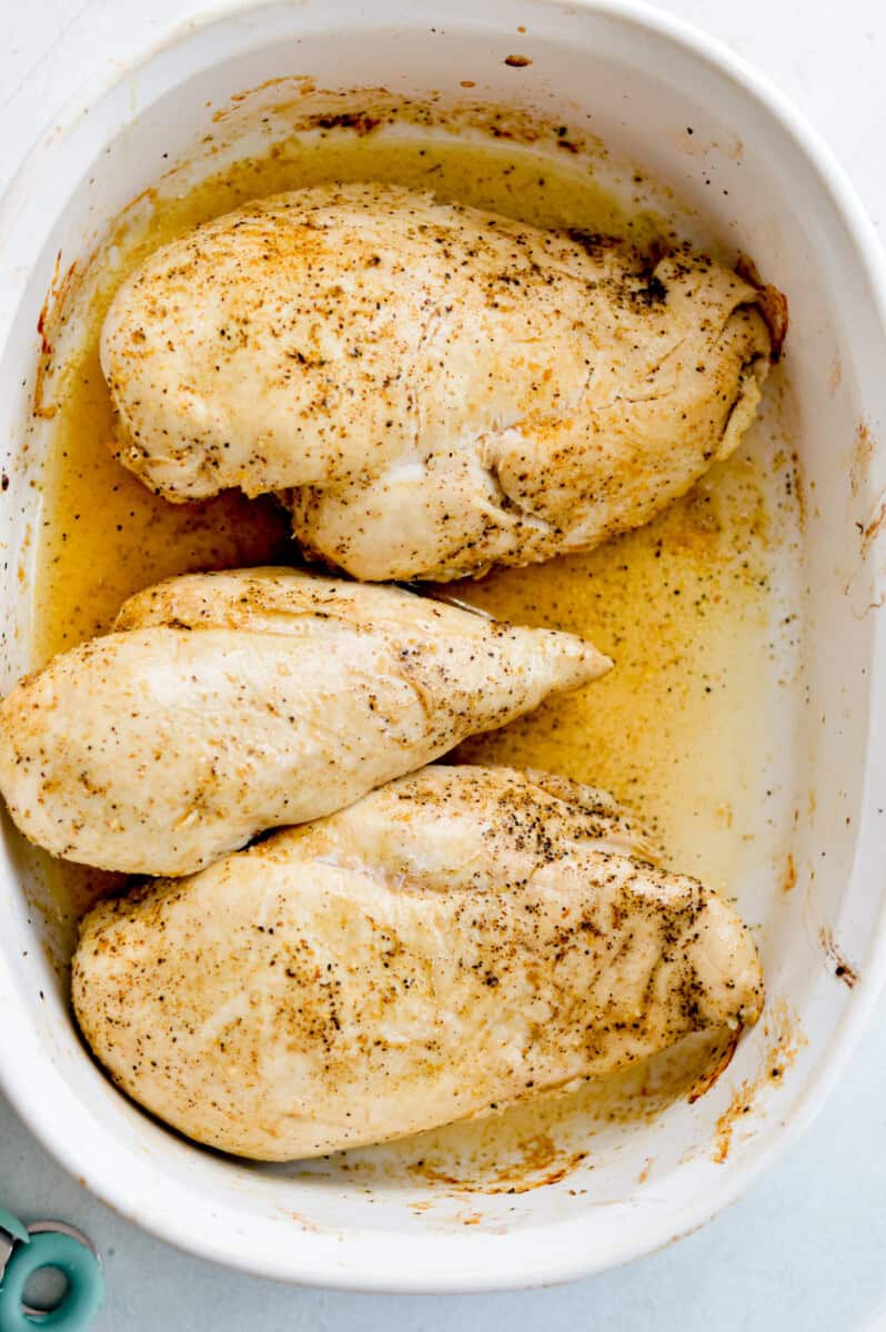 Marinating 3 chicken breasts in a dish.