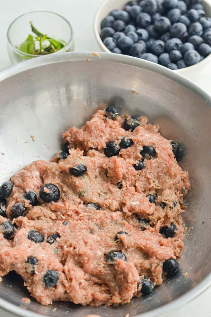 Mixing blueberries into turkey meat mixture.