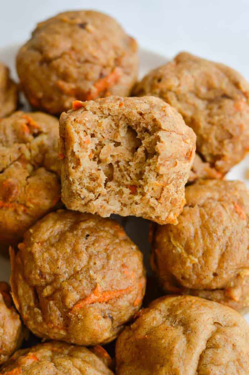 Pile of healthy breakfast muffins with a bite from the top muffin.
