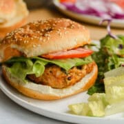 Plate with spicy chicken burger and salad.