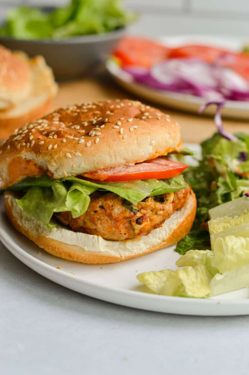 Plate with spicy chicken burger and salad.