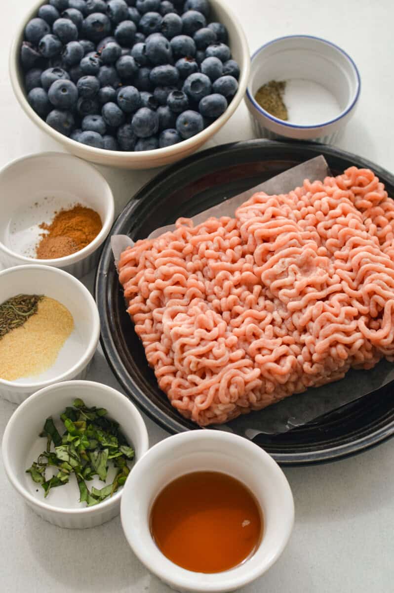 Ingredients including seasoning, basil, ground turkey, blueberries and maple syrup.