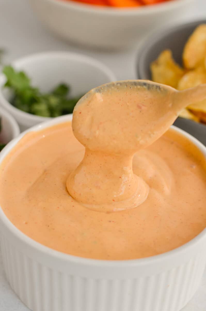 Scooping cottage cheese queso from a bowl.