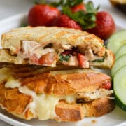 Plate with balsamic strawberry and chicken sandwich with cucumbers and strawberries.