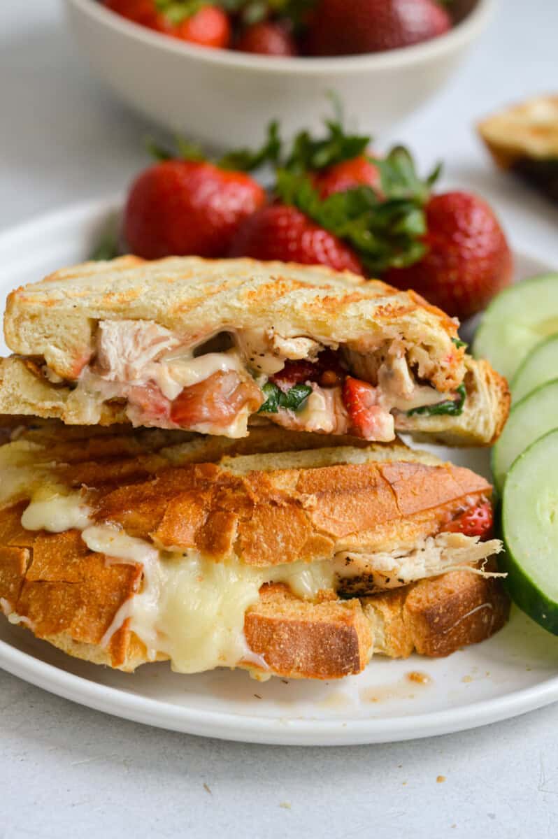 Plate with balsamic strawberry and chicken sandwich with cucumbers and strawberries.