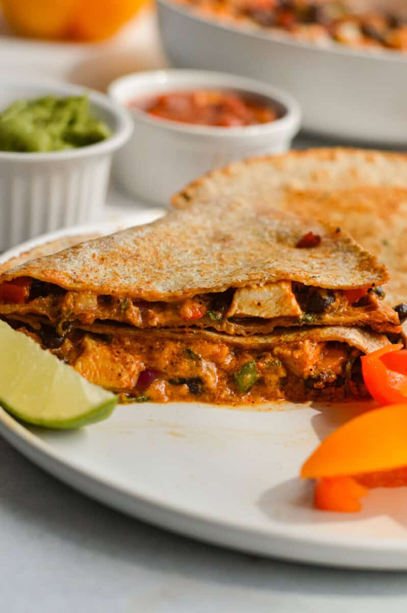 Side view of bbq chicken and black bean quesadilla sliced in half.