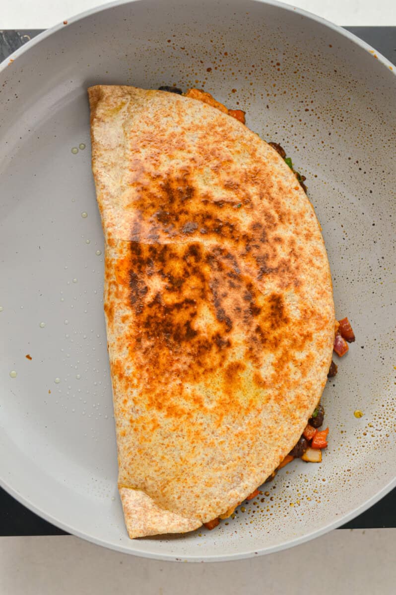 Cooking a bbq chicken and black bean quesadilla.