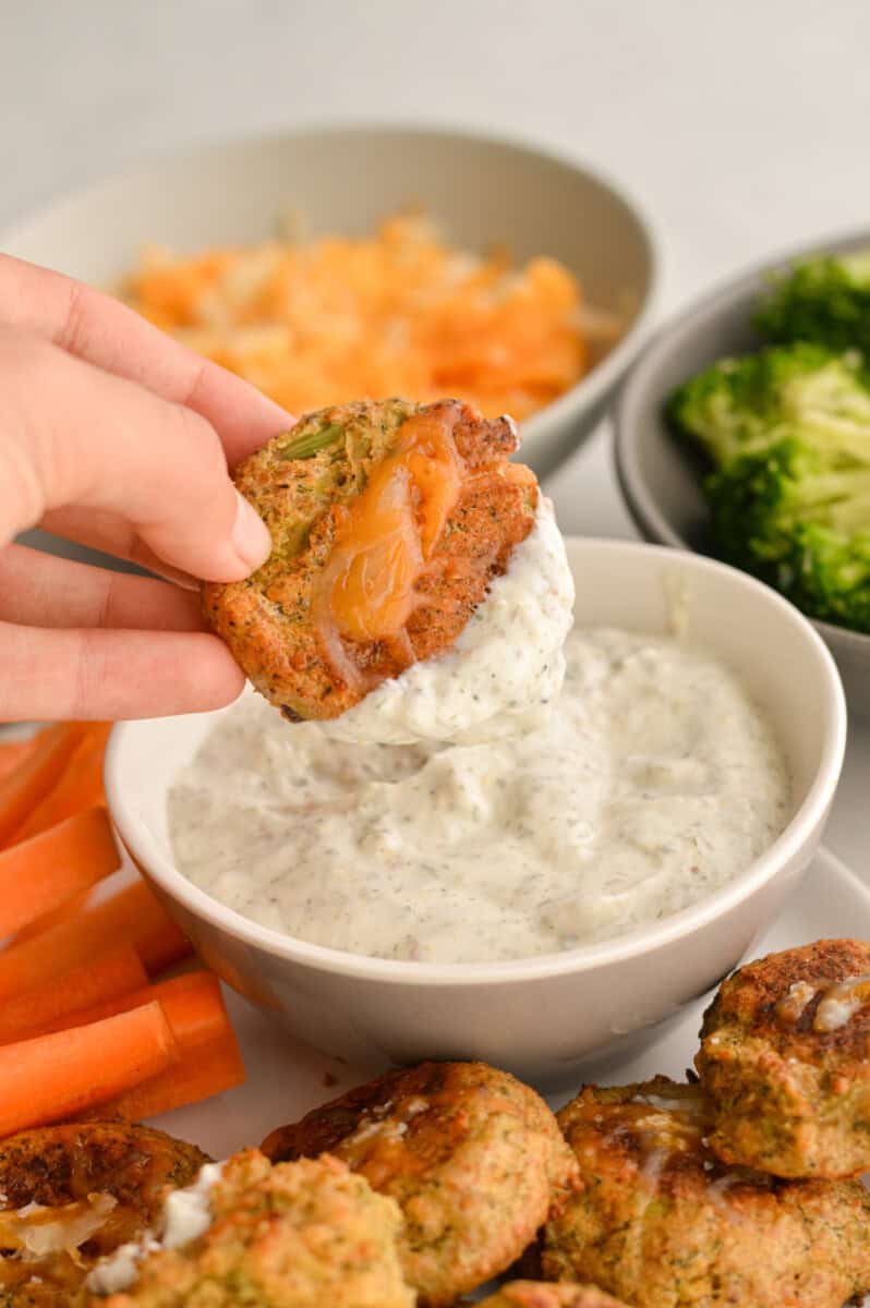 Dipping broccoli bites into greek yogurt dip.