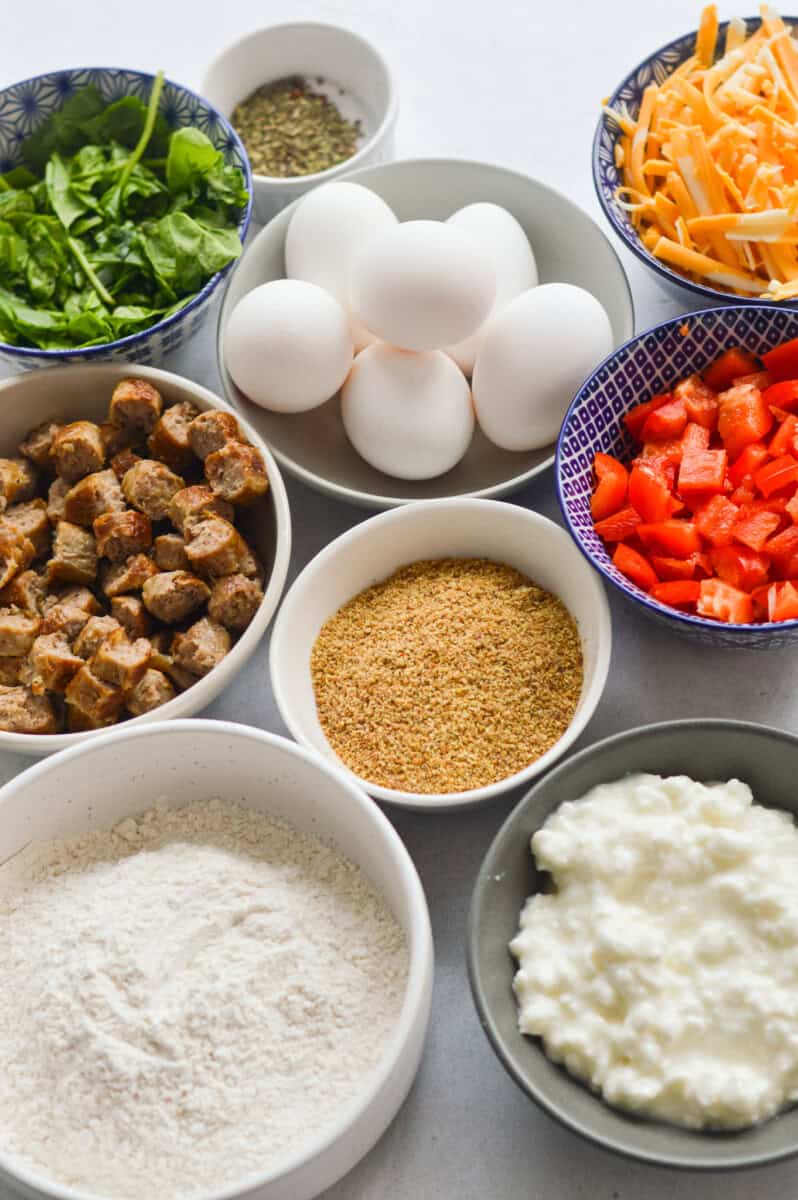 Ingredients including eggs, cottage cheese, veggies, spices, sausage, flaxseed and flour.