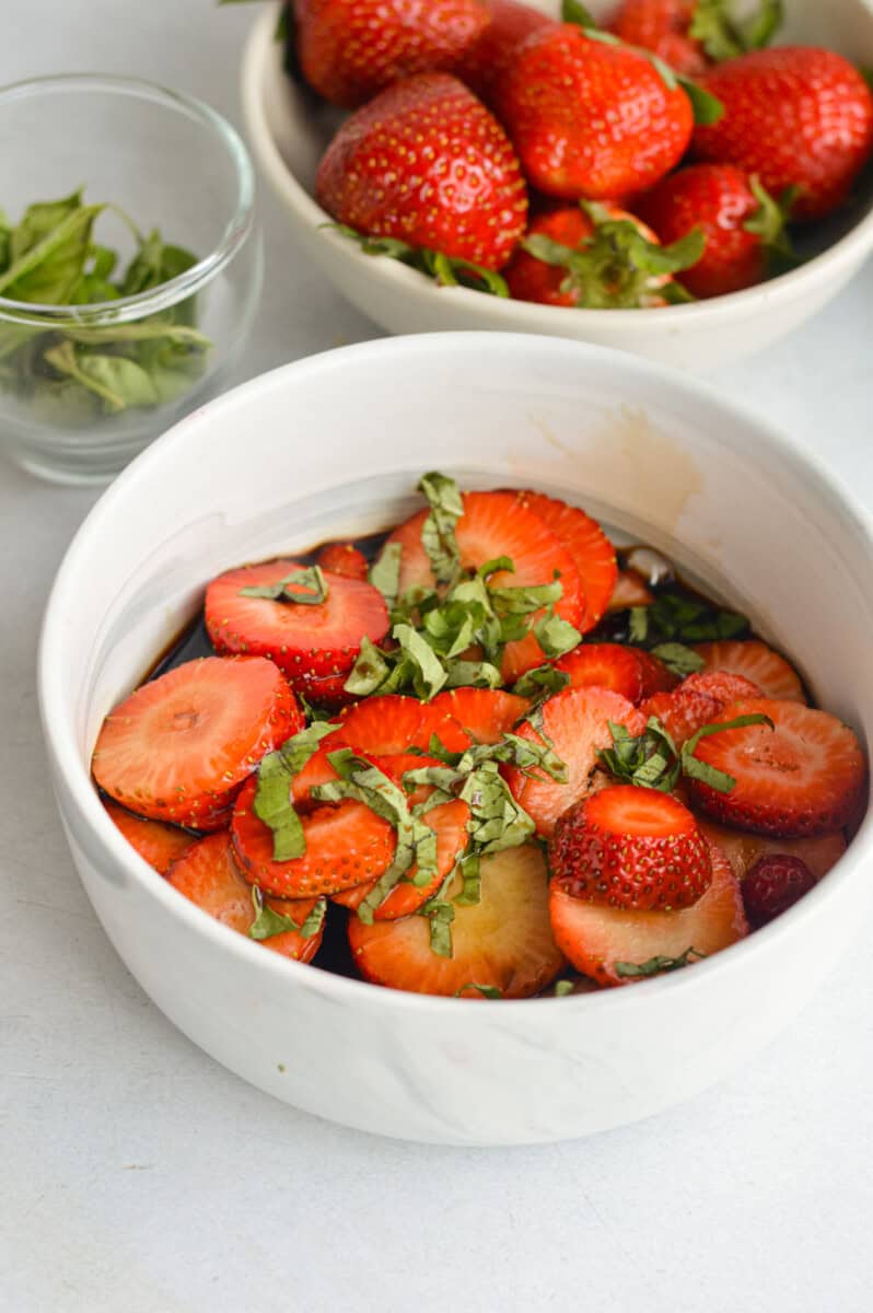Marinating strawberries in balsamic vinegar and basil.
