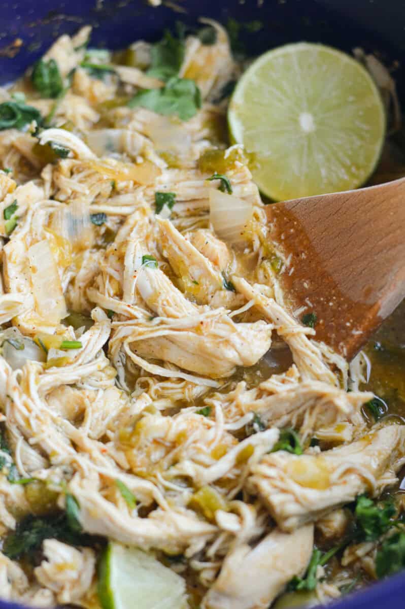 Stirring crockpot green chili chicken.