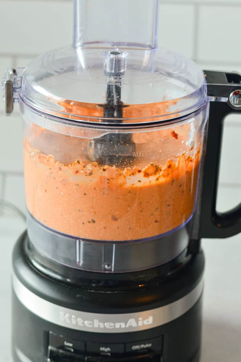 Blending tomato cottage cheese sauce in a food processor.