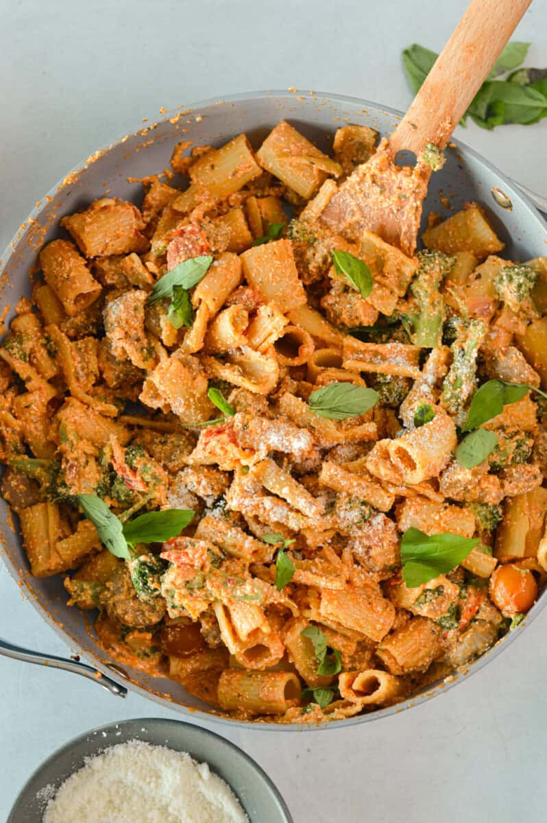 Birds eye of a pan of pasta with sausage and broccoli.