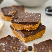 Two stacked chocolate peanut butter protein bars.