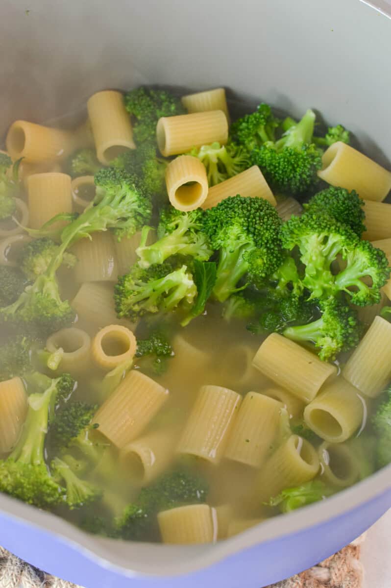 Boiling broccoli and pasta together.
