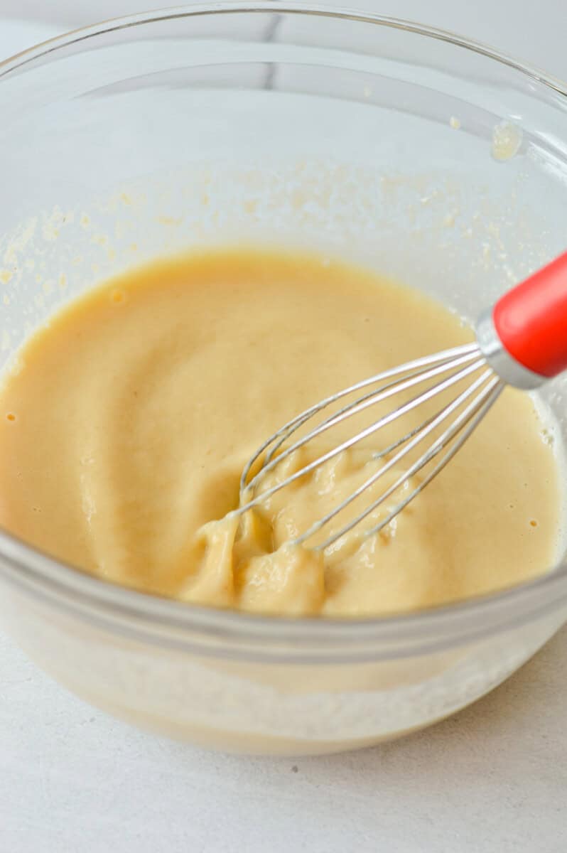 Whisking together applesauce, Greek yogurt, eggs, maple syrup and vanilla extract. 