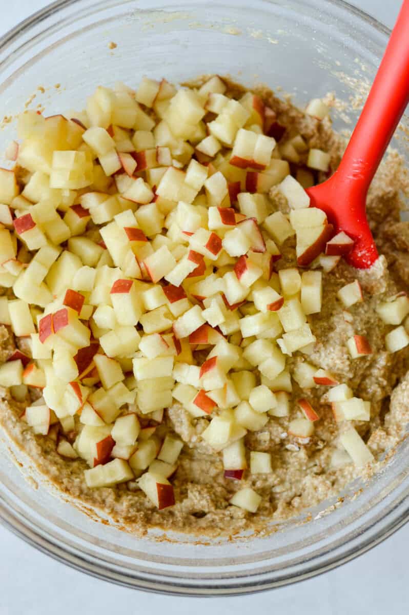 Folding in diced apples to oat batter.