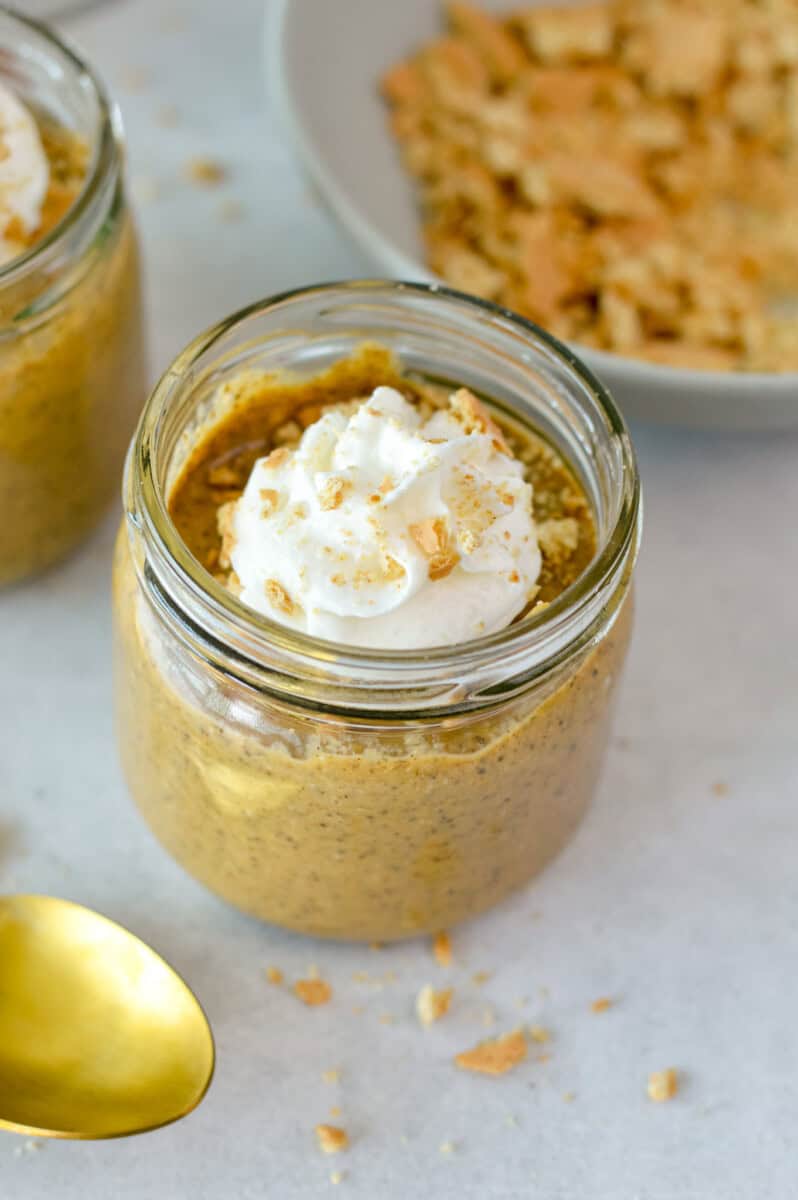 Jar of pumpkin chia pudding topped with whipped cream.