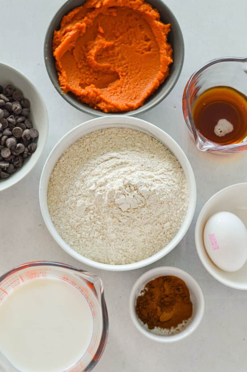 Ingredients including protein pancake mix, pumpkin puree, chocolate chips, egg, maple syrup, milk, and spices.