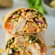 Two halves of a BBQ grilled chicken wrap stacked.