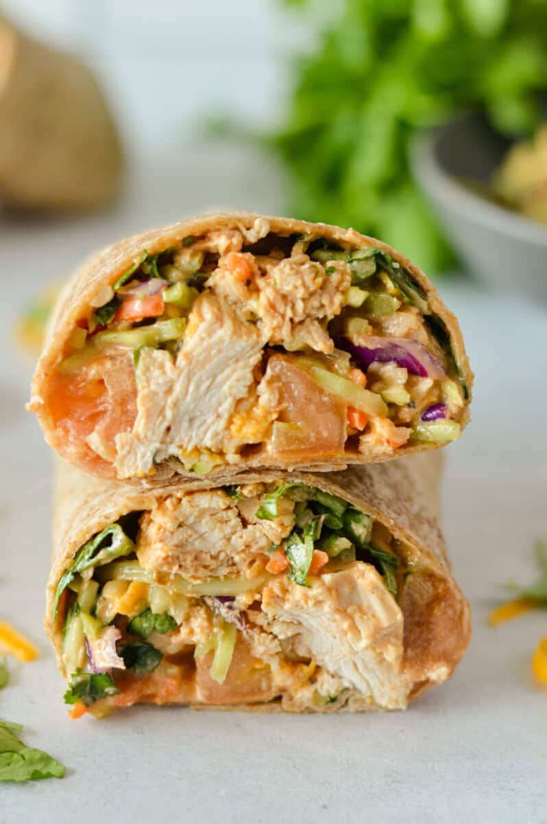 Two halves of a BBQ grilled chicken wrap stacked.