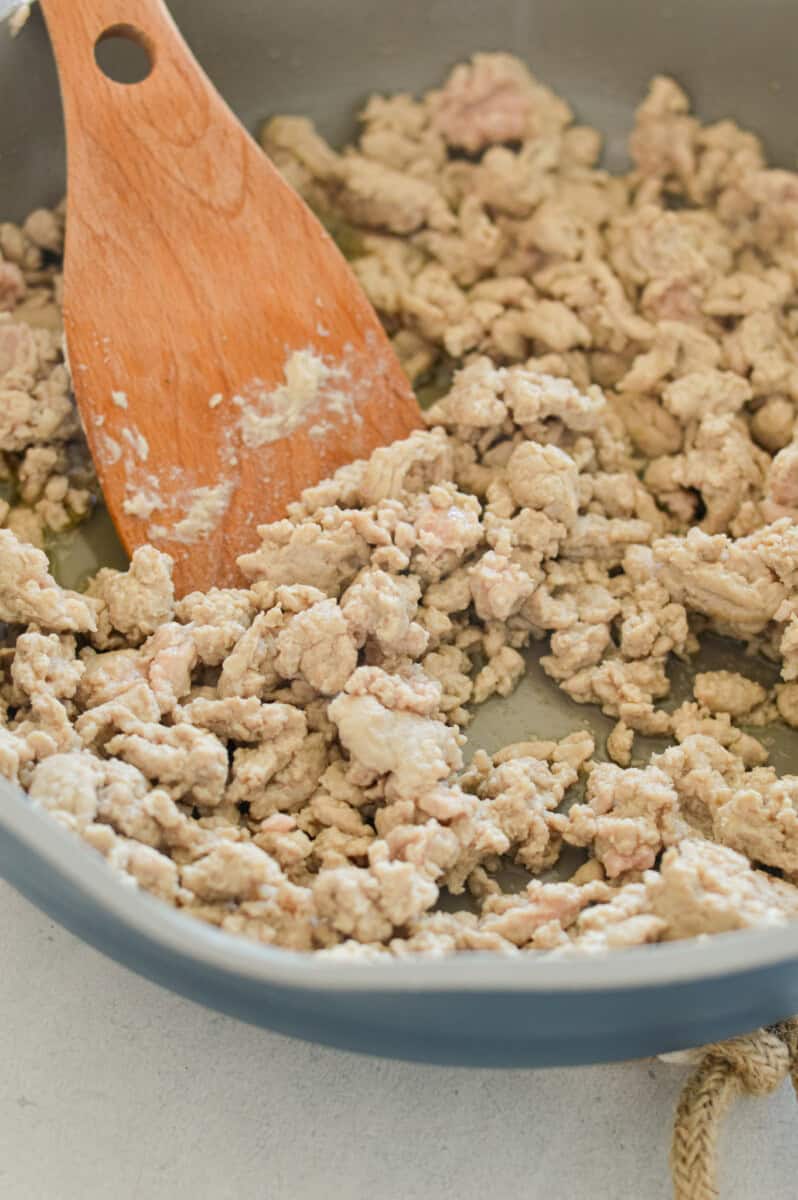 Cooking ground chicken in a pan.