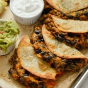 Tray of crispy chicken baked tacos served with greek yogurt and guac.