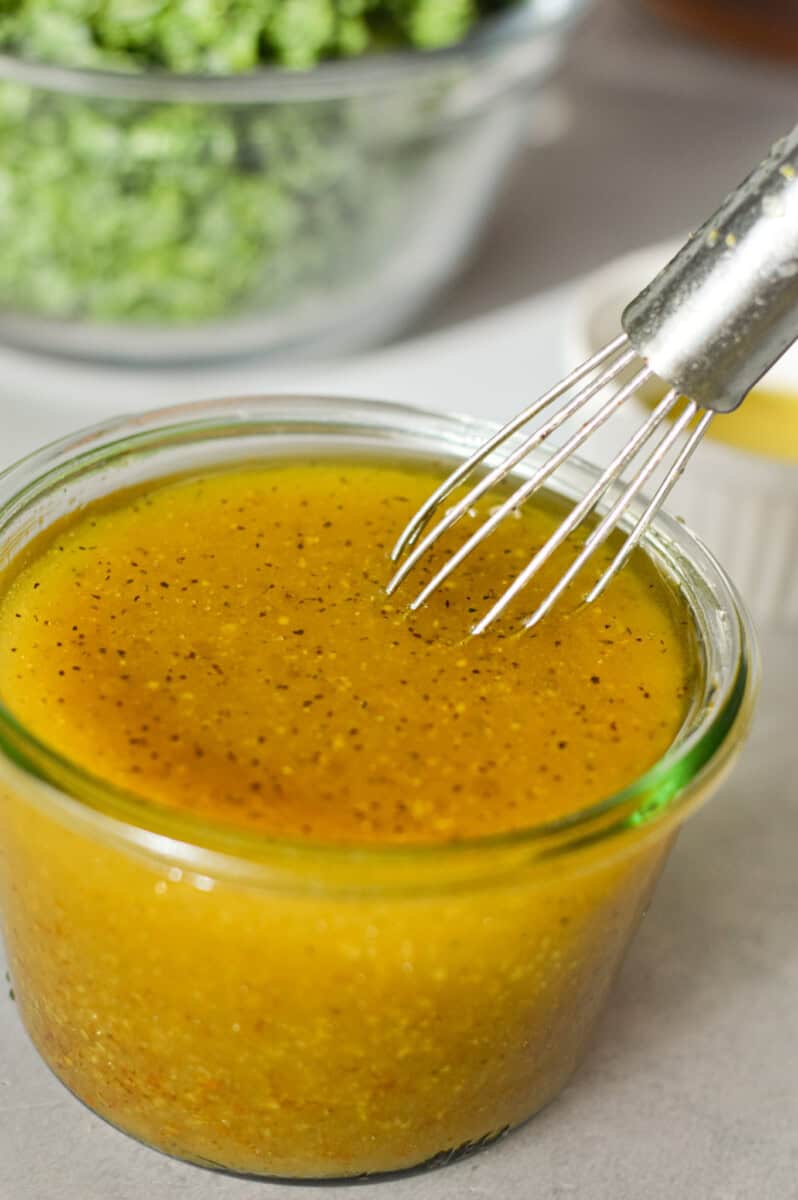 Whisking together a maple dijon vinaigrette in a jar.