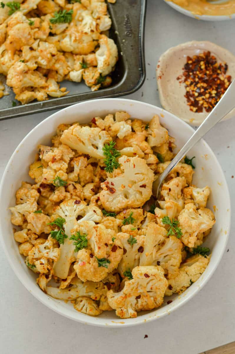 Birds eye of a bowl of oven roasted cauliflower with tahini sauce.