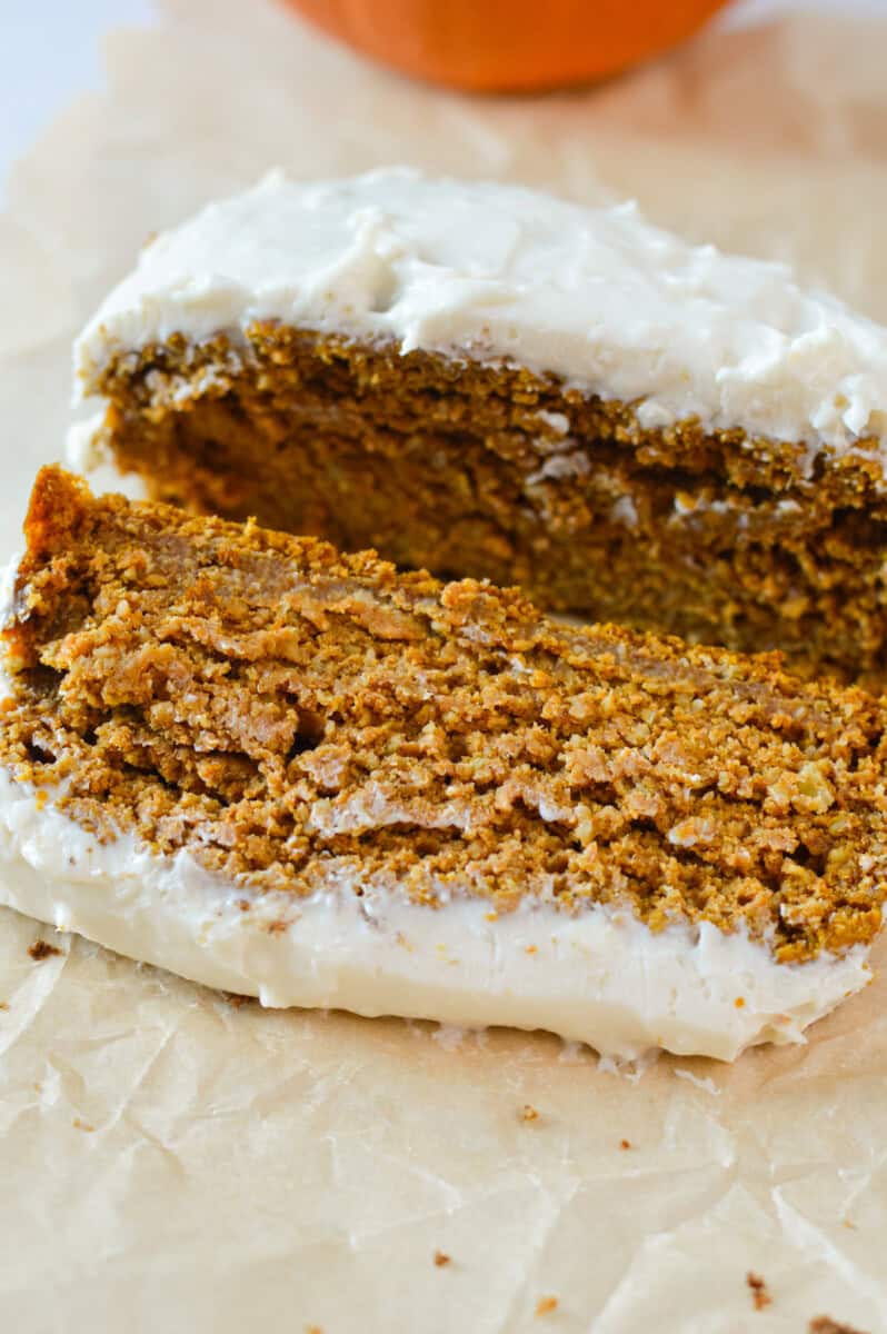 Slice of gluten free pumpkin bread with cream cheese frosting.