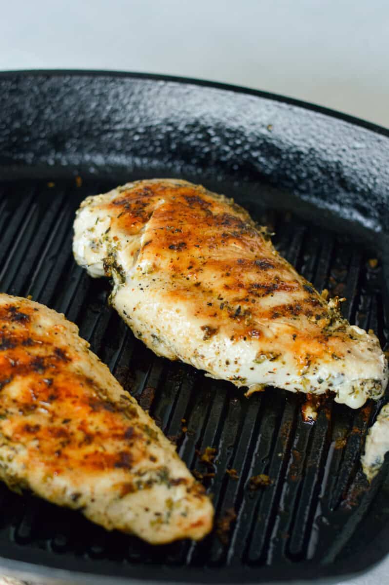 Grilling chicken breasts on a pan.