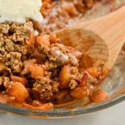 Close up of healthy apple crumble recipe with a wooden serving spoon.