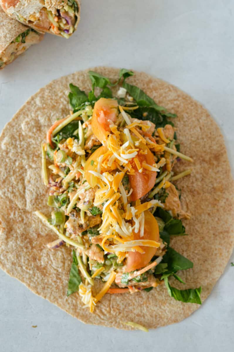 Making a bbq chicken wrap with a whole wheat tortilla.