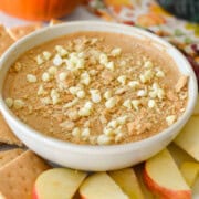 Bowl of pumpkin pie cream cheese dip topped with mini white chocolate chips.