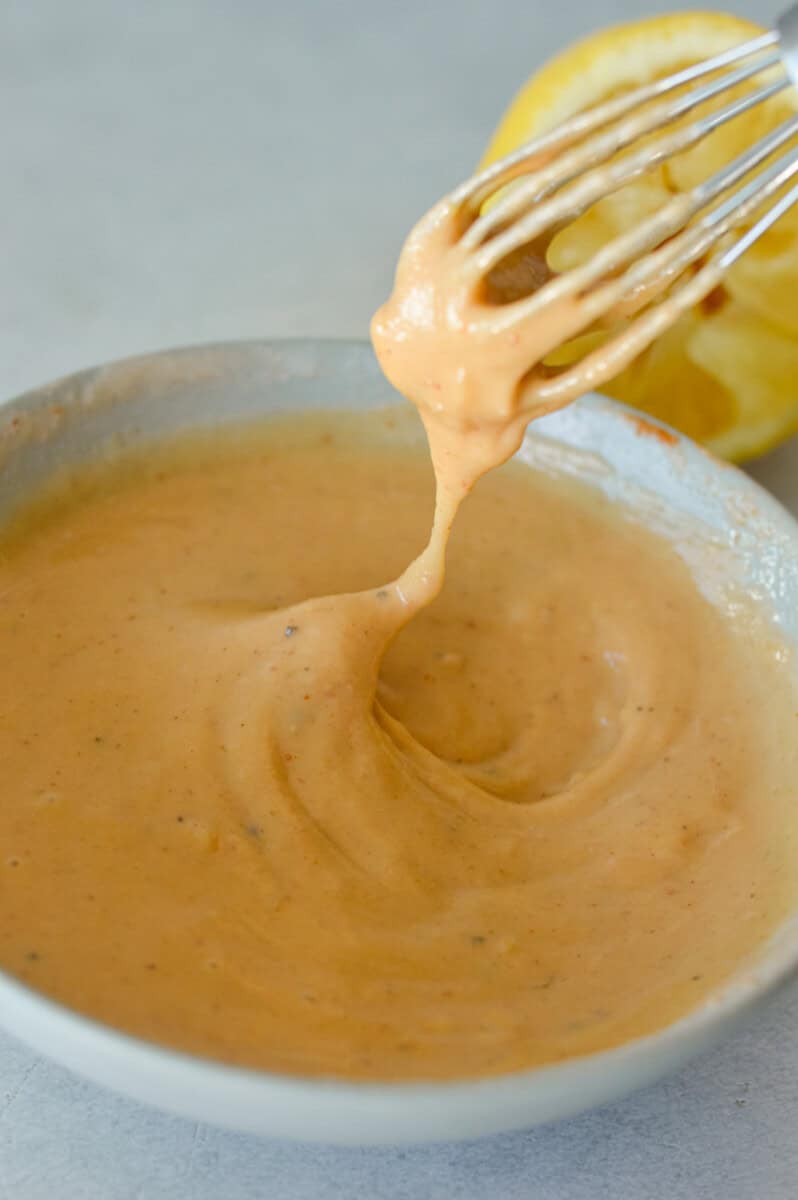 Whisking together tahini sauce.