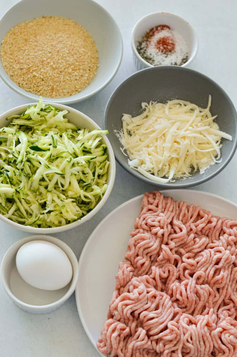 Ingredients including zucchini, ground turkey, egg, cheese, spices, breadcrumbs.