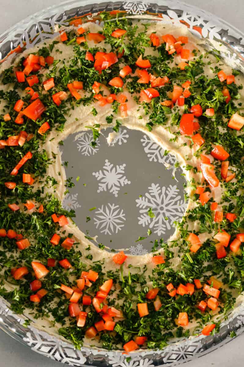 Over the parsley, top with diced red pepper and crumbled feta cheese.
