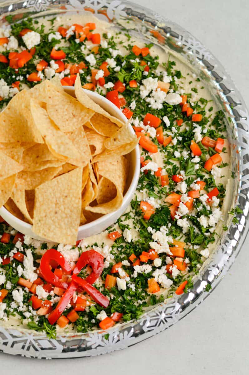 Birds eye of hummus wreath with tortilla chips in the middle.