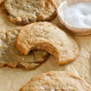 Chocolate chipless cookies on a tray, with a bite out of one.