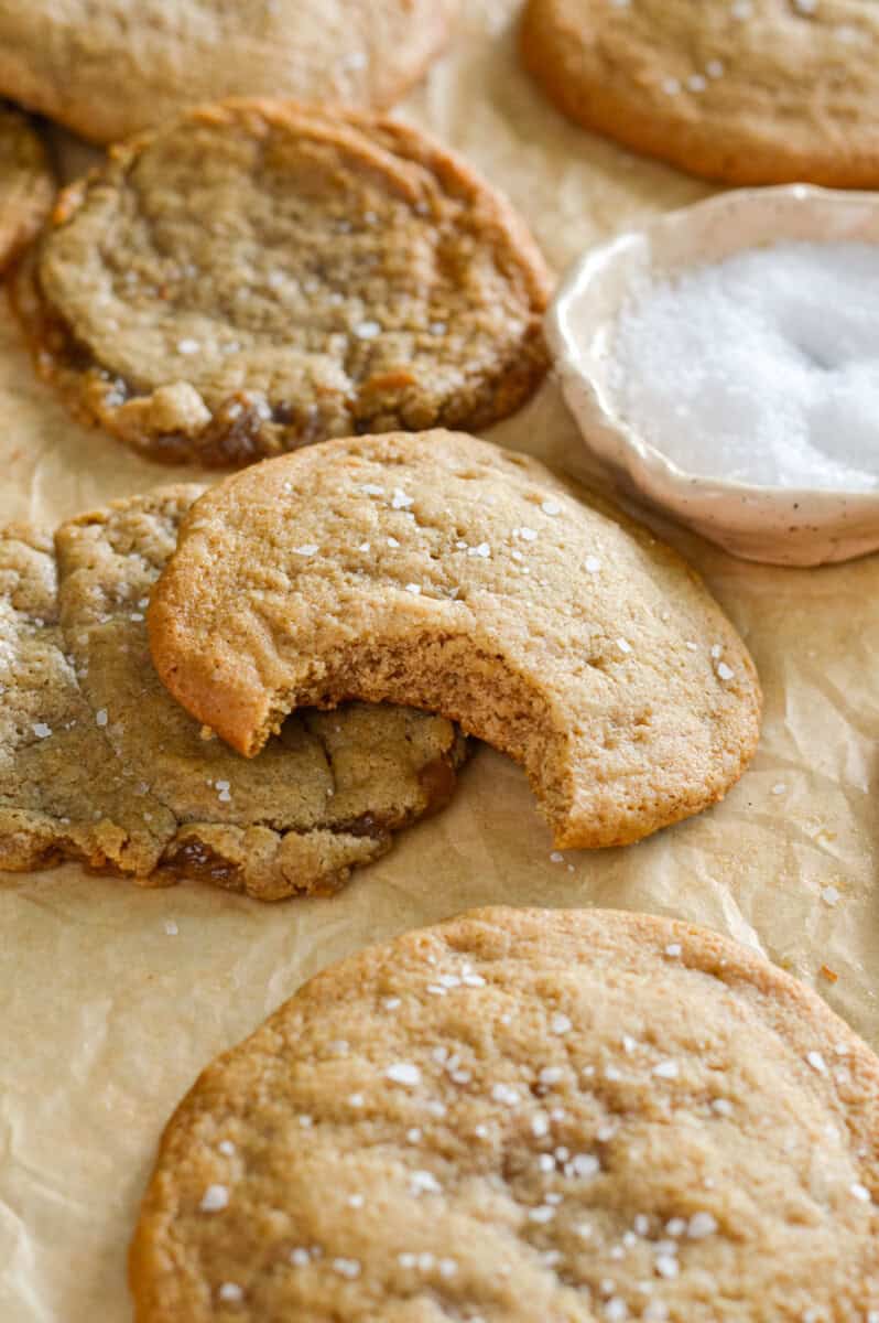 Chocolate chipless cookies on a tray, with a bite out of one.