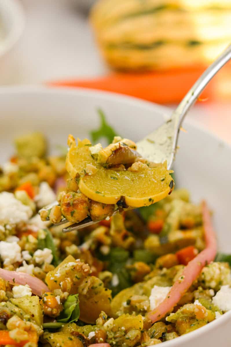 Close up of eating a roasted vegetable salad with a fork.