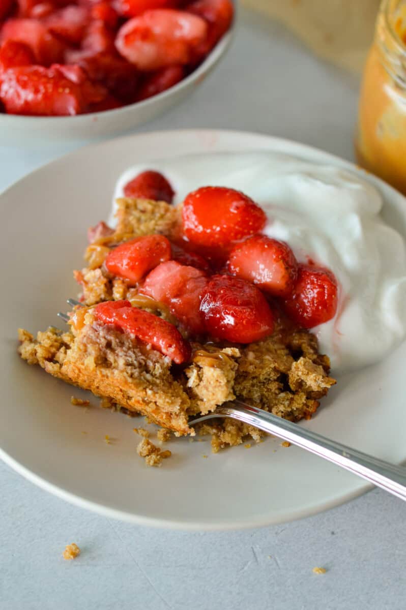 Eating a strawberry oatmeal bar topped with diced strawberries.