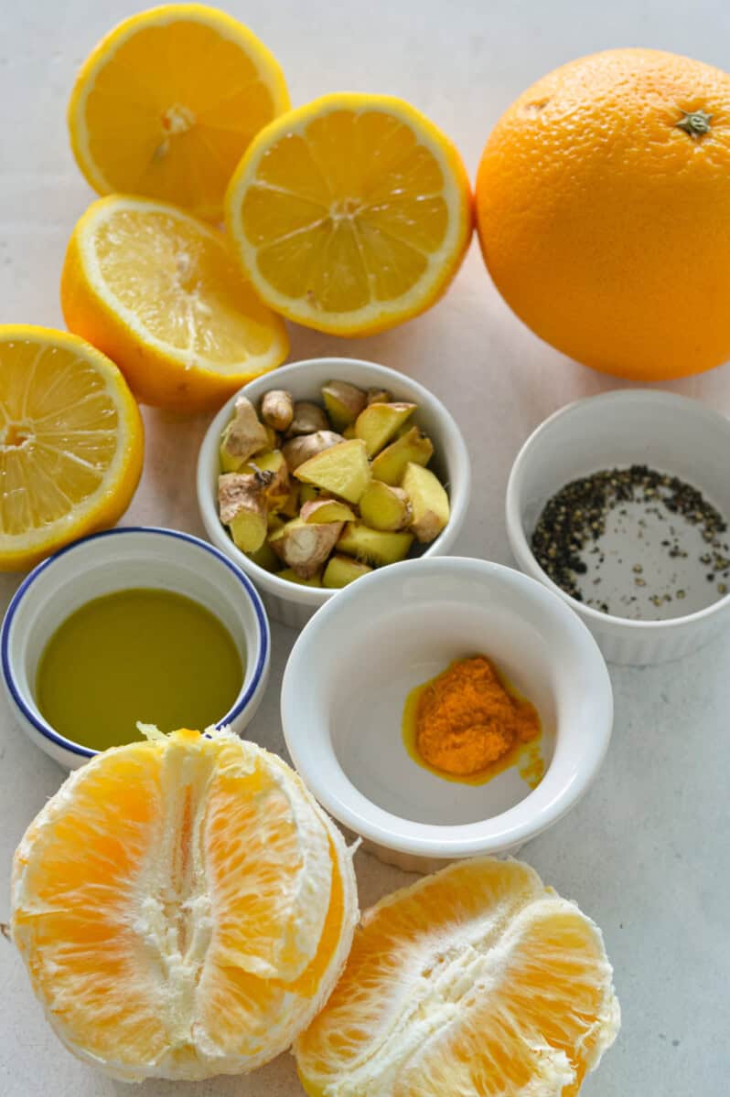 Ingredients including oranges, fresh ginger, fresh turmeric, lemon juice, spices and olive oil.