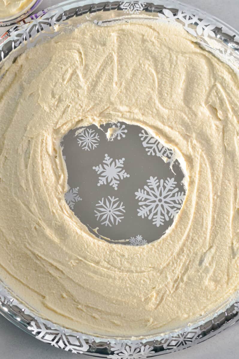 Spreading hummus to make the base of the hummus wreath.