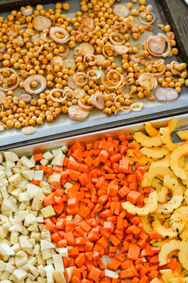 Two trays of chickpeas, squash, carrots and parsnips.