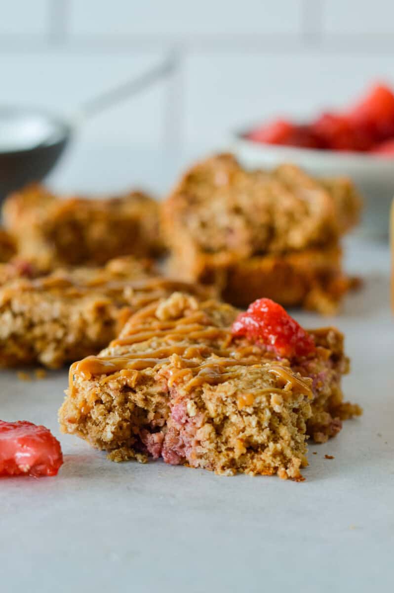 A strawberry oatmeal bar with more bars in the background.