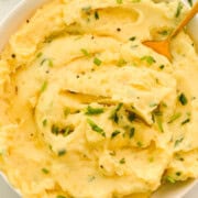 Birds eye of bowl of yukon gold mashed potatoes topped with chives.
