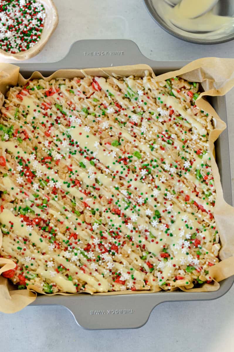 A pan of Christmas rice krispies treats with white chocolate drizzle.